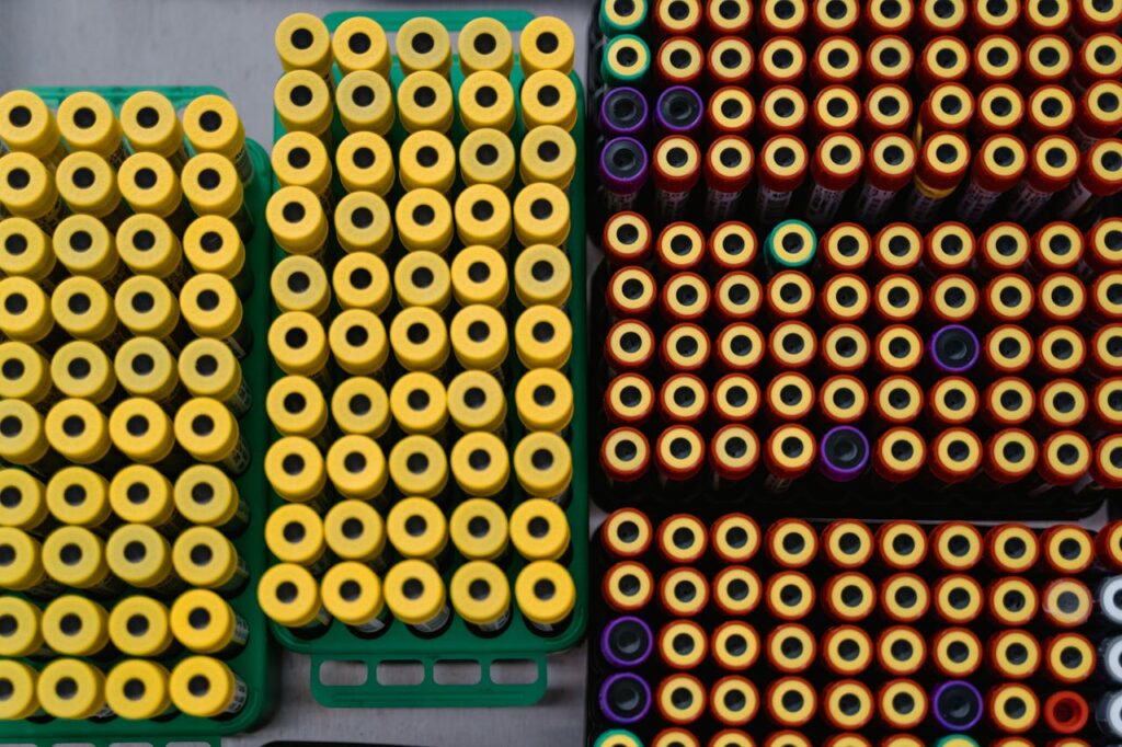 Multiple rows of organized test tubes viewed from above in a laboratory setting.